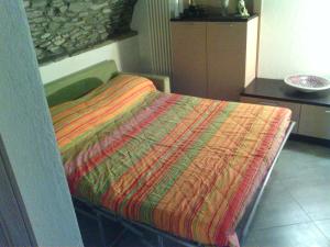 ヴァルトゥルナンシュにあるCasa Valtournencheのベッド(カラフルな毛布付)