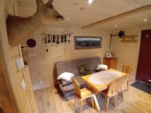 a dining room with a table and a deer head on the wall at Chatka w Dolinie in Witów
