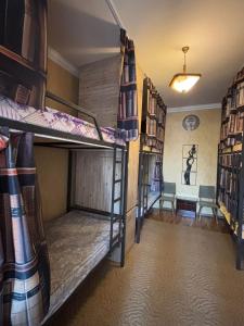 ein Zimmer mit zwei Etagenbetten und einem Schreibtisch in der Unterkunft Pariss Library Hostel in Yerevan