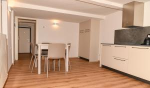 a kitchen and dining room with a table and chairs at Aosta Holiday Apartments - Croix-de-Ville in Aosta