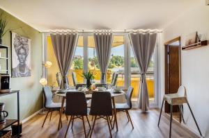 Un comedor con mesa y sillas y una gran ventana. en Superior App 238 mit Pool und Sauna, en Braunlage