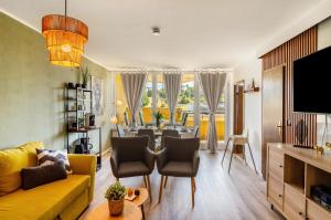 Una sala de estar con un sofá amarillo y una mesa. en Superior App 238 mit Pool und Sauna, en Braunlage