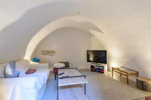 un salon avec un canapé blanc et une télévision dans l'établissement Mas des Flaux beautiful authentic house with tennis court, à Oppède 25 autres photos