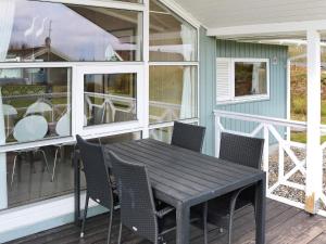 a porch with a table and chairs on a house at 4 star holiday home in Hadsund in Hadsund