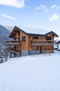 a log cabin in the snow with snow covered ground at CHALET ALIET 1500 - 18 personnes PEISEY NANCROIX - LES ARCS - LA PLAGNE - PARADISKI in Peisey-Nancroix