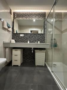 a bathroom with a sink and a mirror at Apartamento Somo Playa con garaje, Cantabria in Somo +25 photos