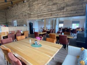 a dining room with a large wooden table and chairs at 8 Seasons Hotel in Varangerbotn