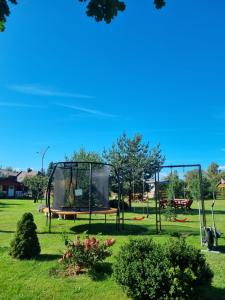 a park with two swings in the grass at Namelis Šventoji in Palanga