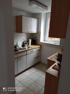 a small kitchen with white cabinets and a window at Gasthof ´s Gräbele in Tübingen
