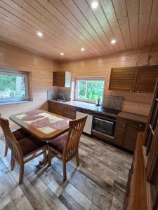 a kitchen with a table and chairs in a cabin at Namelis Šventoji in Palanga