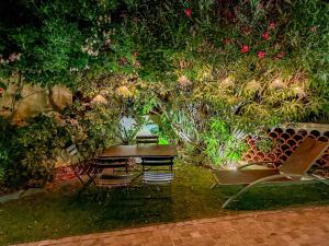 a table and chairs in a garden with plants at Luxueux haut de villa 4 per à 30m de la plage in Sainte-Maxime