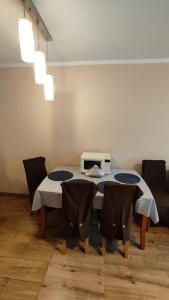 a dining room with a table with chairs and a microwave at Apartament pod Górą Chełmską in Koszalin +11 photos