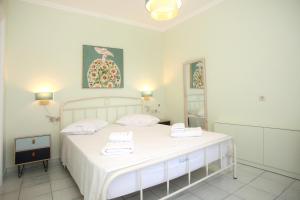 Un dormitorio con una cama blanca con dos toallas encima. en Casa de Marion, en Lefkada 14 fotos más