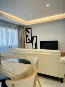a living room with a white couch and a table at La Cabane Fuengirola in Fuengirola