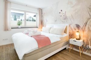 a bedroom with a large white bed with a window at FENJOY Ferienwohnungen am Chiemsee - Zentral - BBQ in Bernau am Chiemsee