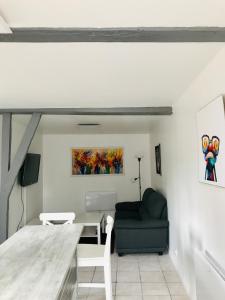 a living room with a table and a chair at Charmante petite maison à la campagne in Soulanges