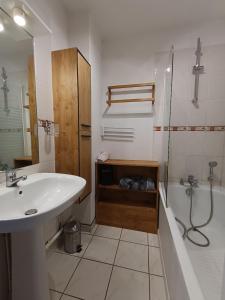 une salle de bain avec un lavabo, une douche et une baignoire dans l'établissement Maison provençale avec piscine partagée, à Loriol-du-Comtat