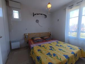 une chambre avec un lit avec une couette jaune et bleue dans l'établissement Maison provençale avec piscine partagée, à Loriol-du-Comtat 11 autres photos