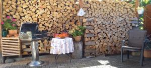 a wall with a pile of wood next to a table at Relax apartma Peter in Ptuj +45 photos