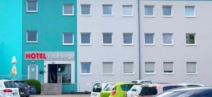 a hotel with cars parked in front of a building at VitaLounge Sports & Spa Hotel in Gelsenkirchen