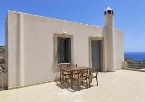 a patio with a table and chairs on a building at Horizon in Kythira