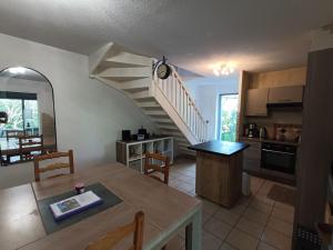 une cuisine et une salle à manger avec un escalier en colimaçon dans l'établissement Maison provençale avec piscine partagée, à Loriol-du-Comtat