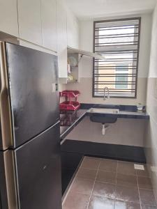 une cuisine avec un réfrigérateur en acier inoxydable et un évier dans l'établissement Infinity Homestay Bandar Cemerlang, à Ulu Tiram 4 autres photos