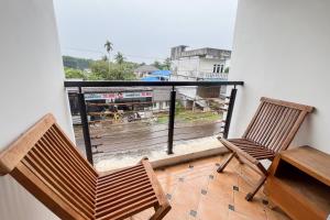 due sedie e un tavolo su un balcone con vista di RedDoorz at Kanaka Hostel Tanjung Pinang a Tanjung Pinang