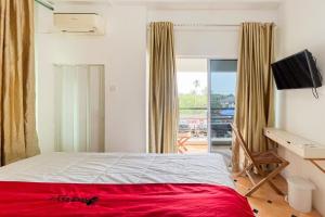 una camera da letto con un letto, una scrivania e una finestra di RedDoorz at Kanaka Hostel Tanjung Pinang a Tanjung Pinang