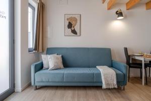 a blue couch in a living room with a table at Authentic Studio with Terrace by HostWise in Porto