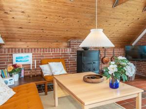 a living room with a table and a fireplace at 6 person holiday home in Ringkøbing in Ringkøbing +14 photos