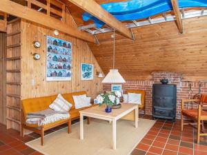 a living room with a couch and a table and a stove at 6 person holiday home in Ringkøbing in Ringkøbing
