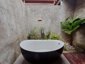 a bath tub in a bathroom with plants at Royale Riviera Resort Private Pool Villas in Pantai Cenang