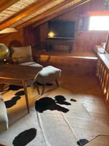 a living room with a table and chairs and a television at Kircher Hütte in Diex