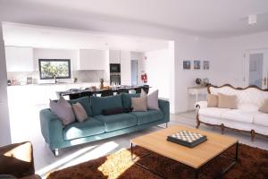 a living room with a blue couch and a kitchen at Villa Seixo - Spa, Beach and Nature in A dos Cunhados