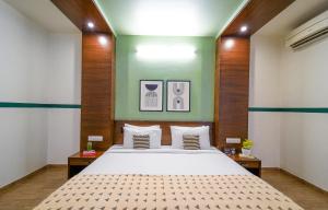 a bedroom with a bed and a green wall at Olive Hotel Electronic City by Embassy Group in Bengaluru