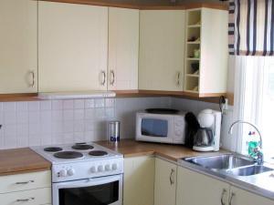 a kitchen with a stove and a microwave at 6 person holiday home in LJUNG-By Traum in Alboga +9 photos