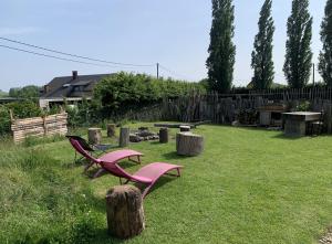 a yard with two pink benches and a fence at Le tipi d'Adri in Gesves