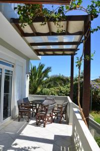 a patio with a table and chairs on a porch at Villa Esperado Gardens Maleme in Maleme +13 photos