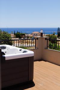 a hot tub on a balcony with a view of the ocean at H&O Villa Arizona Gold Residence in Peyia