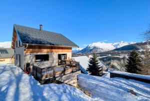 a house covered in snow with mountains in the background at Chalet de l'Aiguille Noire in Montricher-Albanne