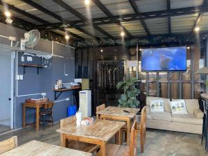 a living room with wooden tables and a tv at Kalis Viewpoint Lodge Coron in Coron