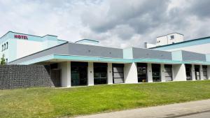 Un gran edificio blanco con un césped verde en el frente. en VitaLounge Sports & Spa Hotel, en Gelsenkirchen