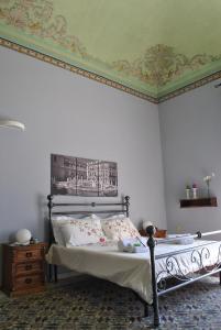 Schlafzimmer mit einem Bett mit Wandgemälde in der Unterkunft Antica Dimora in Palermo