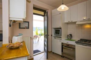 a kitchen with white cabinets and a table with a bowl of food at La Florida in Ameno +49 photos