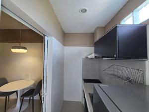 a kitchen with a table and a counter top at Hommory Residence - Phuket Town in Ban Lo Long