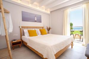 a bedroom with a bed with a view of the ocean at Lefko Fine Maisonettes in Kavos