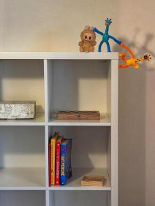 a white book shelf with books and toys on it at Euro Hotel in Nuoro