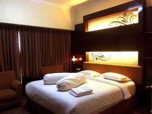 a hotel room with a bed with white sheets and pillows at Lilianto Hotel Polewali Mitra RedDoorz in Campalagiang +53 photos