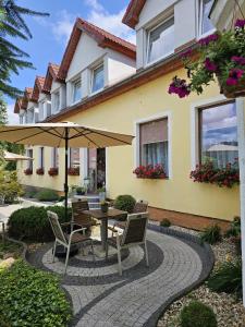 a patio with a table and chairs and an umbrella at POKUSA Noclegi in Przewóz
